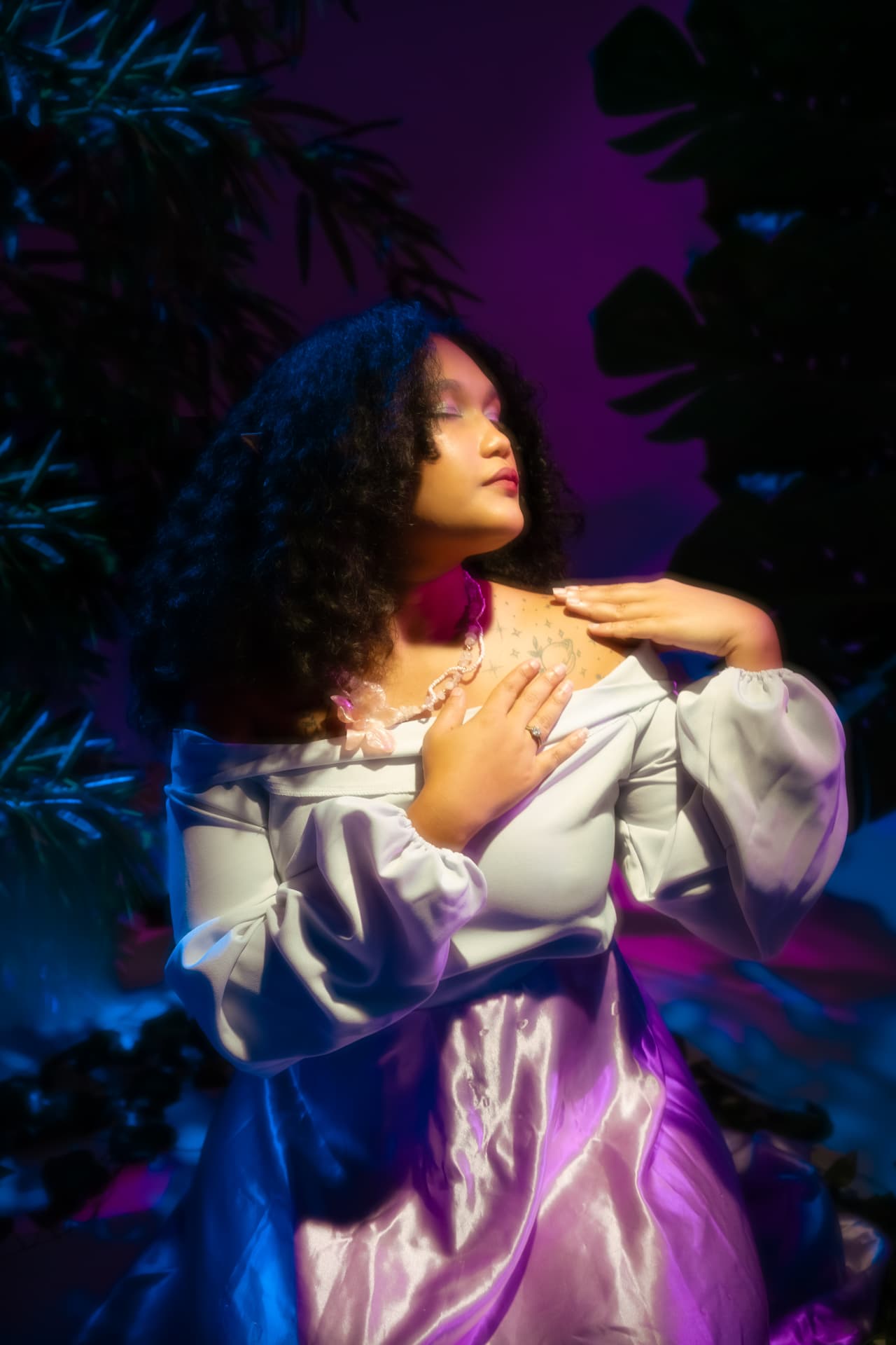 LissySoul iluminada en violeta entre hojas tropicales